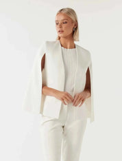 Blazer cape da donna con maniche a spacco su sfondo neutro