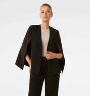 Donna indossa blazer cape bianco con pantaloni sartoriali