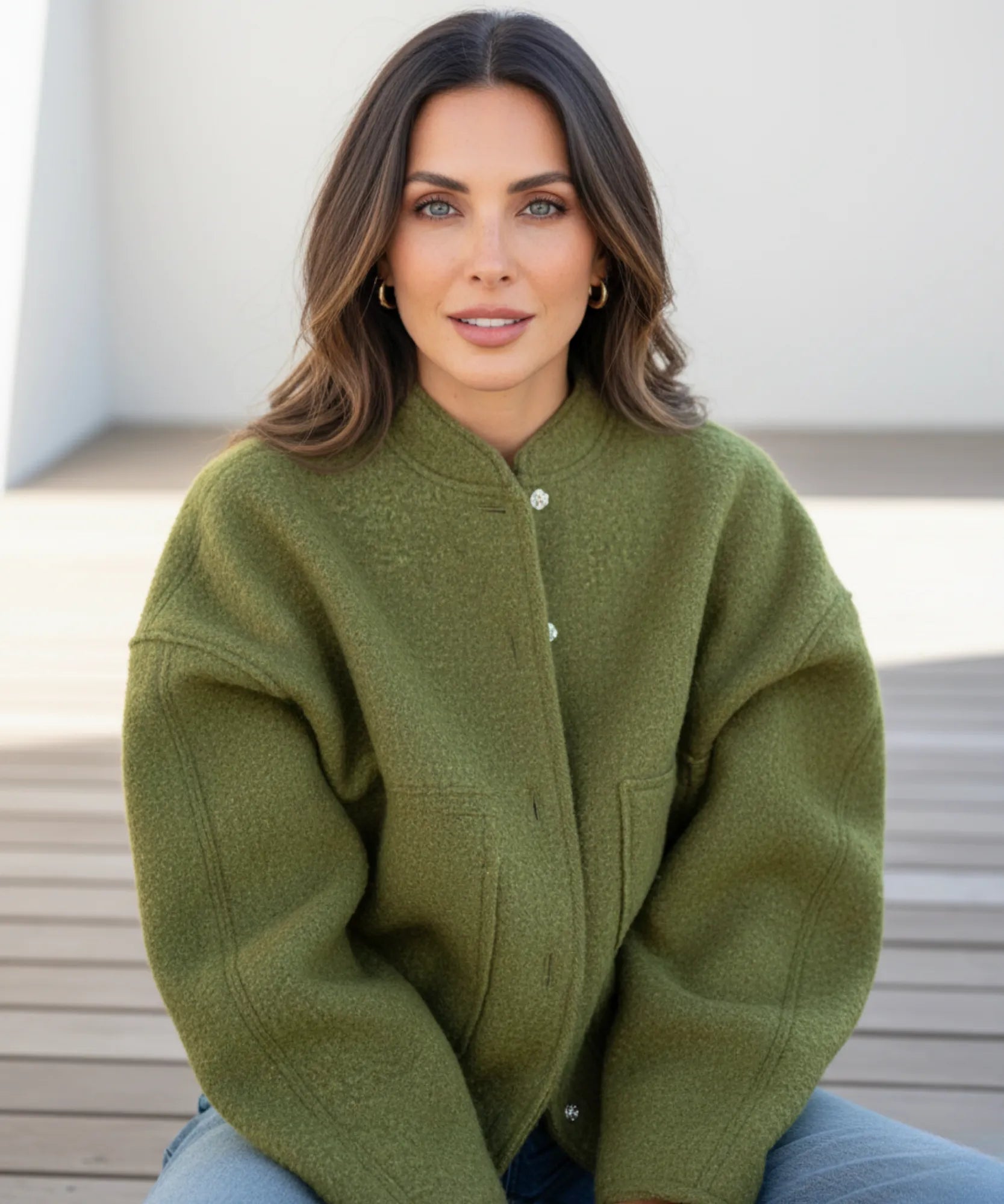 Donna indossa bomber bouclé nera oversize in contesto urbano