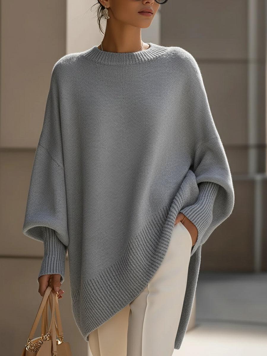 Donna indossa poncho oversize grigio abbinato a jeans