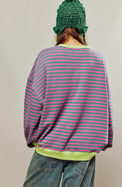 Maglione donna morbido con righe multicolore su sfondo neutro