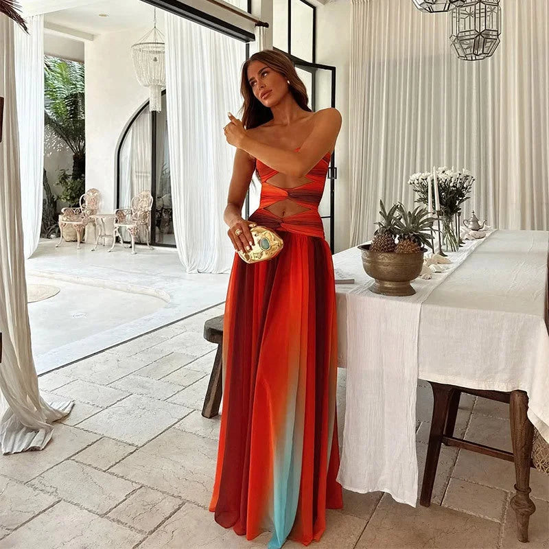 Donna indossa maxi dress estivo con fantasia a blocchi rosso-arancio
