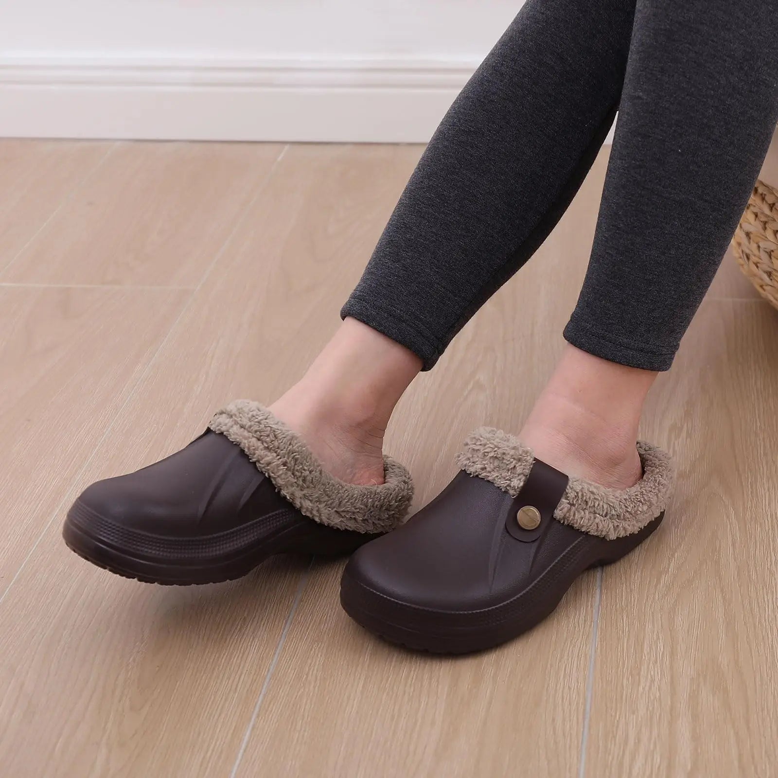 Pantofole Tobia colore nero appoggiate su superficie neutra, look discreto ed elegante